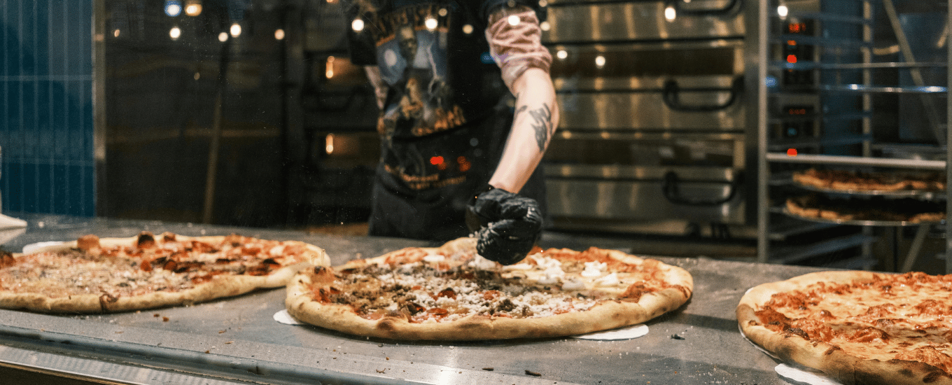 Pizzaiolo przygotowujący pizzę na sprzęcie od Gastroprofit
